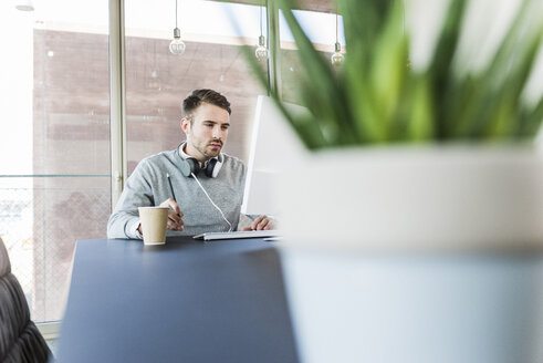 Junger Mann am Bürotisch - UUF007021