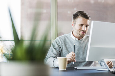 Young man at office desk - UUF007023