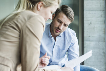 Two colleagues in office talking - UUF007070