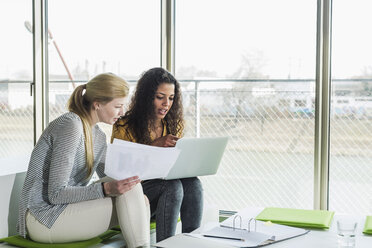 Zwei Frauen im Büro mit Laptop und Dokument - UUF007079