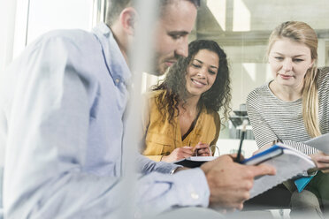 Drei Kollegen im Büro arbeiten zusammen - UUF007088