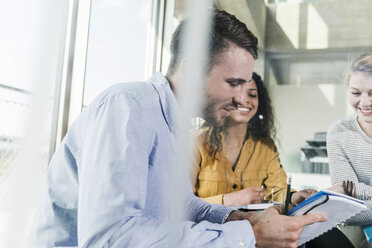 Drei Kollegen im Büro arbeiten zusammen - UUF007089