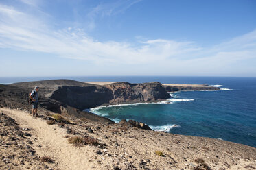 Spain, Canary Islands, Fuerteventura, Jandia, hiker looking to Punta Pesebre - WWF003964