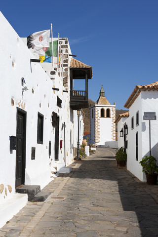 Spanien, Kanarische Inseln, Fuerteventura, Betancuria, Gasse mit Kirche Santa Maria de Betancuria, lizenzfreies Stockfoto