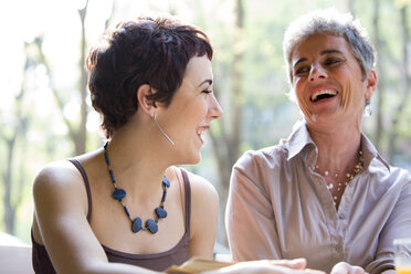 Mother and adult daughter having fun in a pavement cafe - ZOCF000029