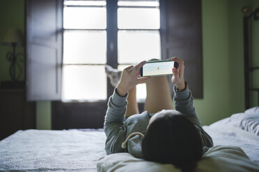 Frau im Bett liegend mit Smartphone - GEMF000865