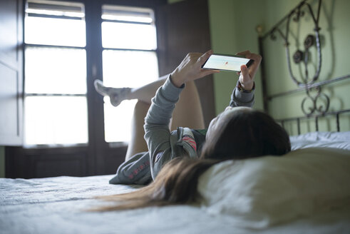 Frau im Bett liegend mit Smartphone - GEMF000868