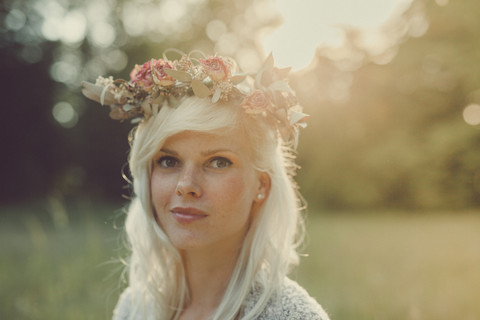 Mädchen mit Blumen im Haar bei Sonnenuntergang, lizenzfreies Stockfoto