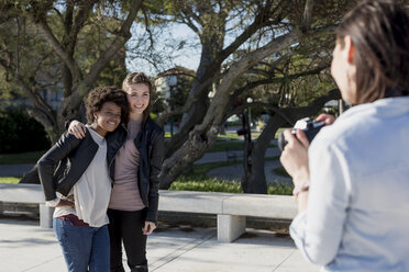 Junge Frau mit Kamera fotografiert Freunde - MAUF000459