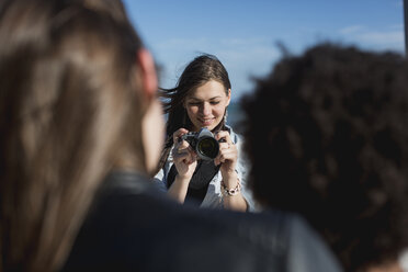 Junge Frau mit Kamera fotografiert Freunde - MAUF000460