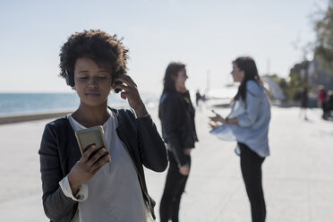 Junge Frau hört Musik mit Smartphone - MAUF000465