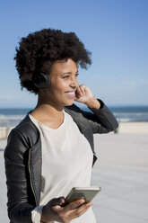 Young woman listening music with smart phone - MAUF000466