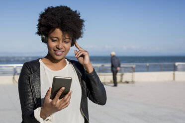Junge Frau hört Musik mit Smartphone - MAUF000467