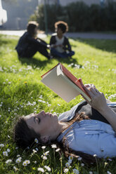 Junge Frau im Park liest ein Buch - MAUF000468