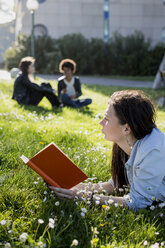Junge Frau im Park liest ein Buch - MAUF000469