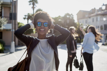 Junge Frau mit Sonnenbrille in der Stadt mit ihren Freunden - MAUF000473