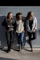 Three young women leaning on wall - MAUF000484