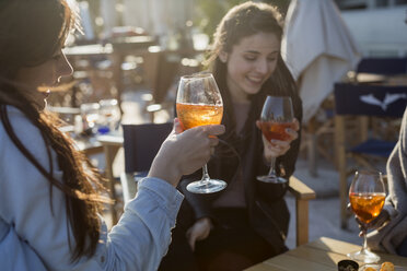 Junge Frauen sitzen in einer Bar und trinken einen Aperitif - MAUF000486