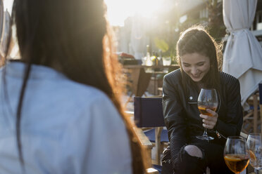 Junge Frauen sitzen in einer Bar und trinken einen Aperitif - MAUF000491