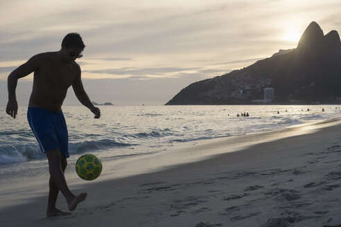 Brasilien, Rio De Janeiro, Mann spielt mit Ball am Strand von Ipanema - MAUF000494