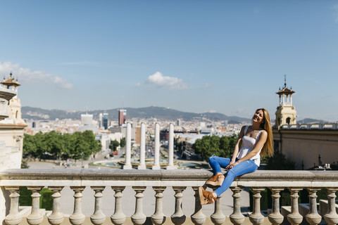 Spanien, Barcelona, Junge Frau genießt Blick auf die Stadt, lizenzfreies Stockfoto