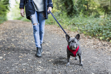 Frau geht mit dem Hund spazieren - MAUF000498