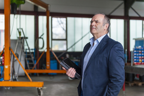 Manager mit digitalem Tablet in der Werkstatt, lizenzfreies Stockfoto