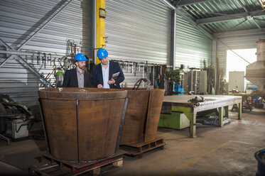 Manager with digital tablet in front of steel tank - DIGF000376