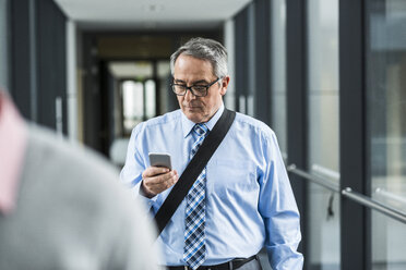 Senior businessman looking on cell phone - UUF007157