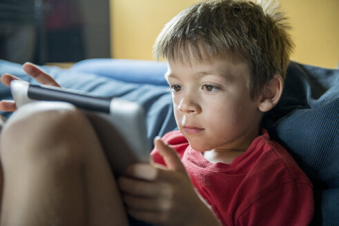 Kleiner Junge benutzt digitales Tablet zu Hause - ZOCF000072