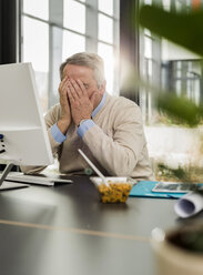 Älterer Mann im Büro, verdecktes Gesicht - UUF007185