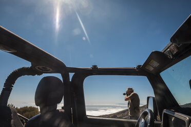 Spanien, Teneriffa, Mann fotografiert neben einem Auto in der Region El Teide - SIPF000368