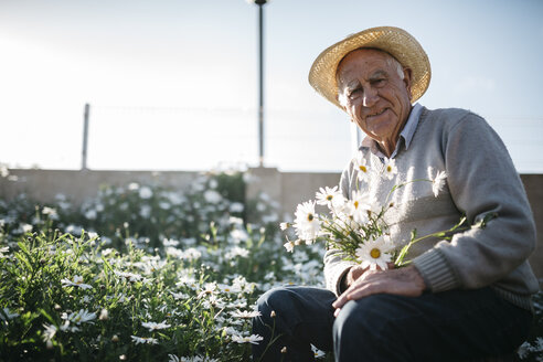 Porträt eines älteren Mannes mit gepflückten Blumen in seinem Garten - JRFF000581