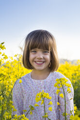 Portrait of smiling little girl in rape field - LVF004803