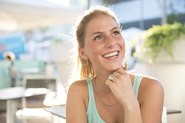 Porträt einer glücklichen jungen Frau in einem Café im Freien im Sommer - ZOCF000076