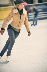 Junge Frau beim Schlittschuhlaufen auf einer Eisbahn im Freien - ZOCF000082