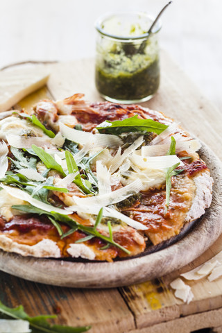 Hausgemachte glutenfreie Pizza mit Mozzarella, Rucola-Pesto, Parmesan und frischem Rucola, lizenzfreies Stockfoto