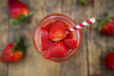 Glass of strawberry smoothie garnished with strawberries seen from above - LVF004809