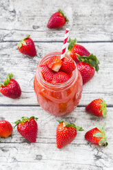 Glas mit Erdbeer-Smoothie und Erdbeeren auf Holz - LVF004814