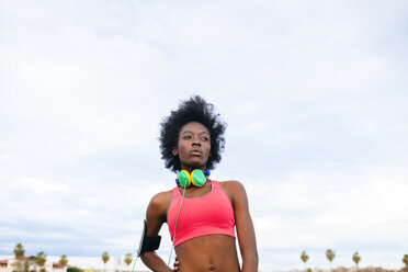 Young black athlete with headphones, portrait - KIJF000395