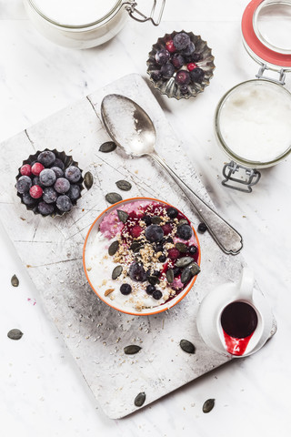 Schale mit veganem Kokosjoghurt mit Beeren, gepufftem Amaranth, Kürbiskernen und Himbeermark, lizenzfreies Stockfoto