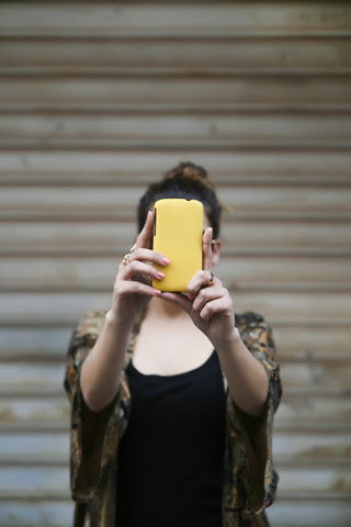 Junge Frau macht ein Selfie mit Smartphone, lizenzfreies Stockfoto