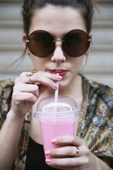 Porträt einer jungen Frau mit Sonnenbrille, die einen Smoothie trinkt - RTBF000161