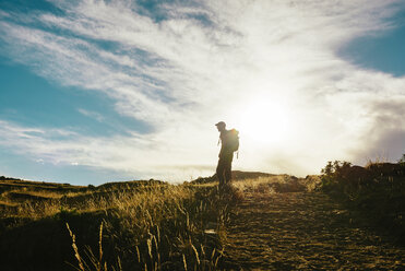 Peru, Amantani Island, silhouette of man with backpack hiking at sunset - GEMF000880