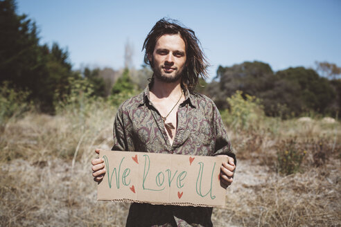 Hippie hält 'We love you'-Schild in der Natur - GIOF000897