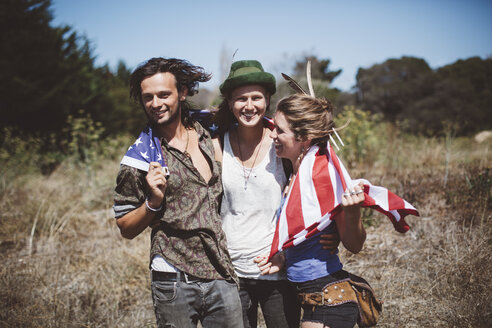 Drei Hippies mit US-Flagge in der Natur - GIOF000898