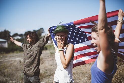 Drei unbekümmerte Hippies mit US-Flagge in der Natur - GIOF000909