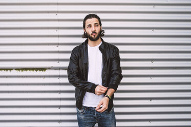 Young man at corrugated iron wall - RAEF001087