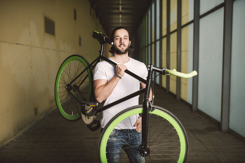 Young man carrying fixie bike - RAEF001117