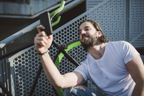 Junger Mann macht ein Selfie im Freien - RAEF001126